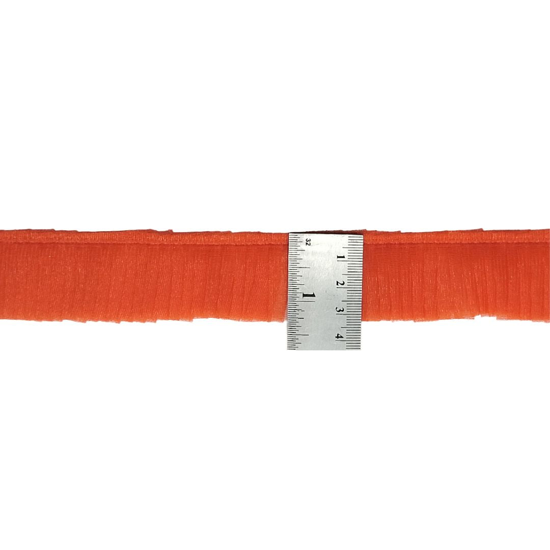 Orange ribbon with a ruler for measurement on a white background
