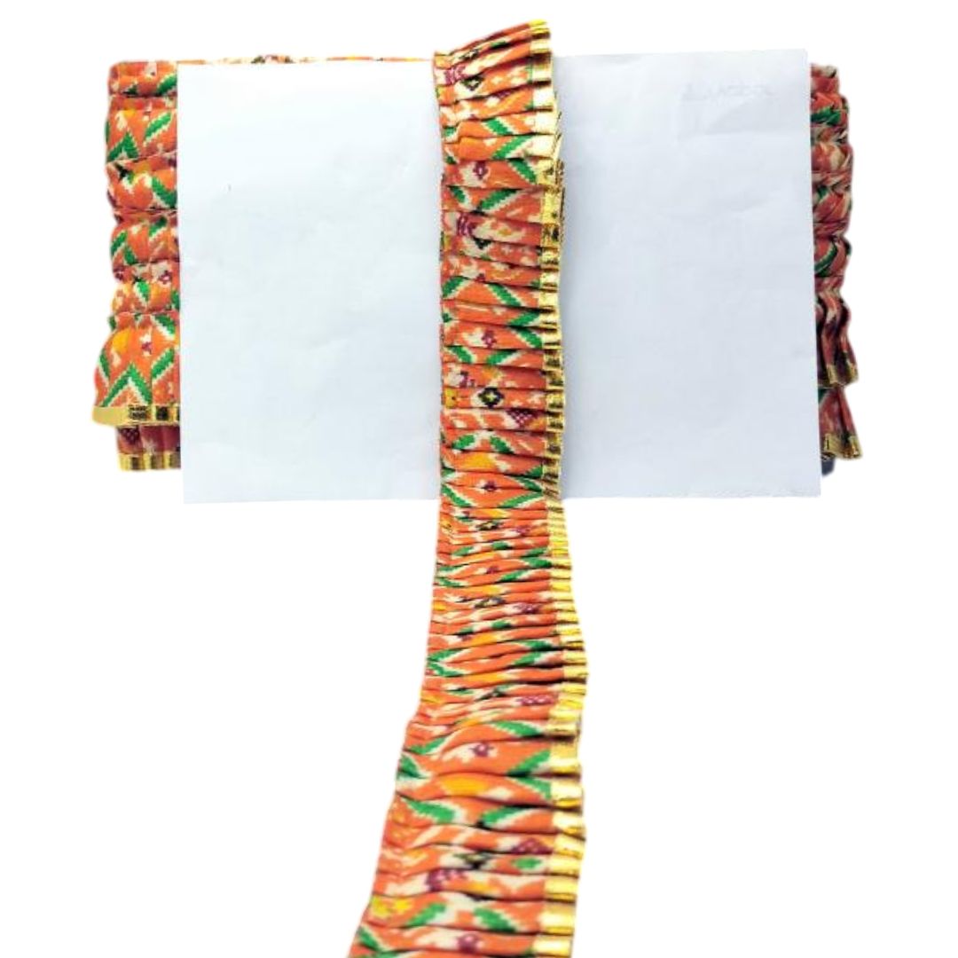 Colorful fabric with a pattern of orange, green, and red on a white background