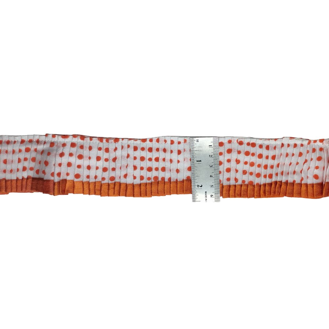 Strip of fabric with orange polka dots and orange border, measured against a white background.