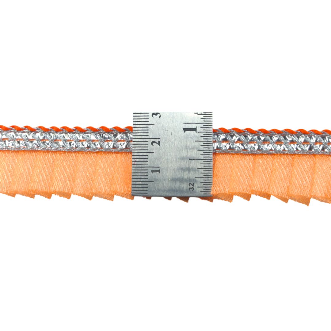 Close-up of orange belt with silver buckle and ruler for scale on a white background