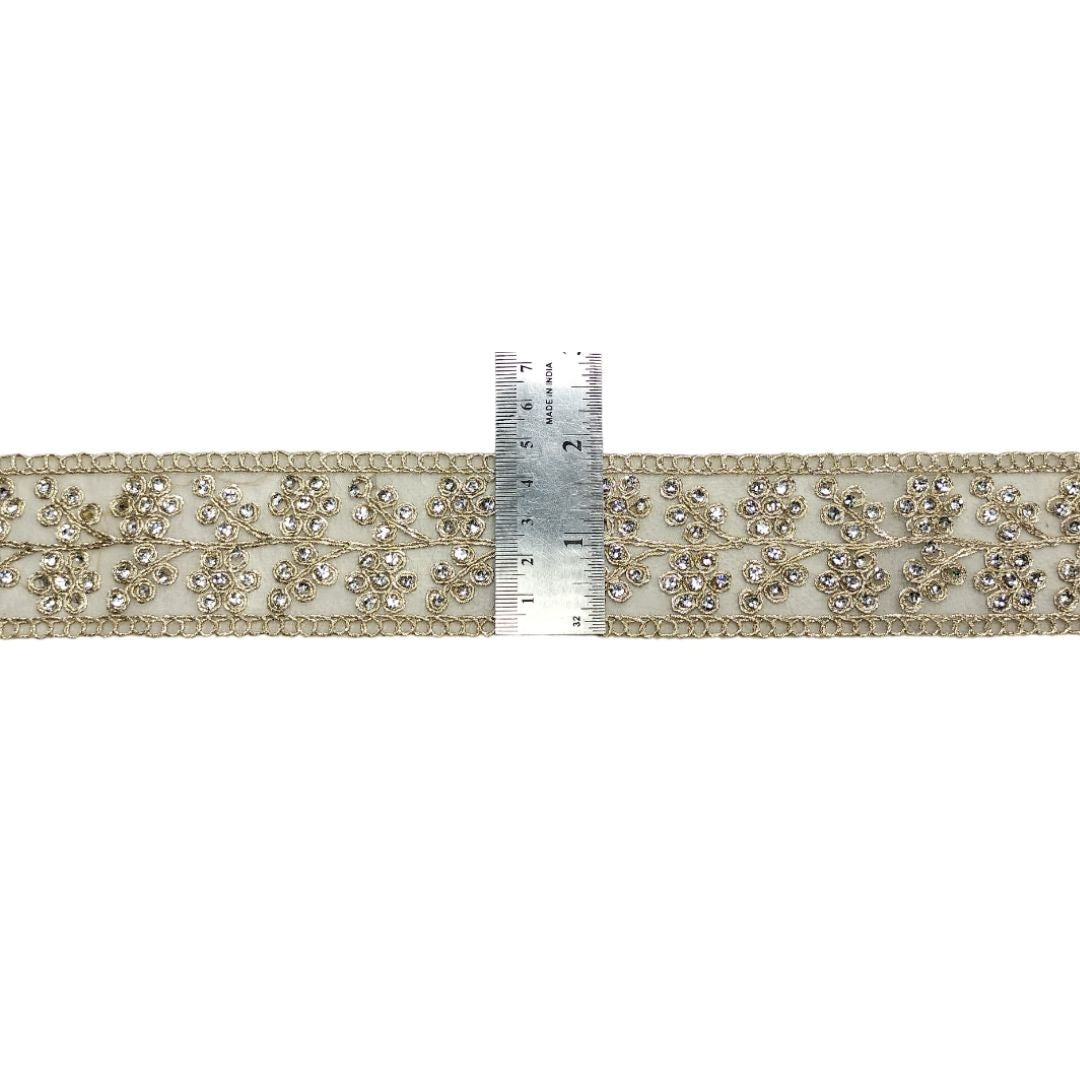 Decorative ribbon with crystal embellishments and a ruler for scale on a white background