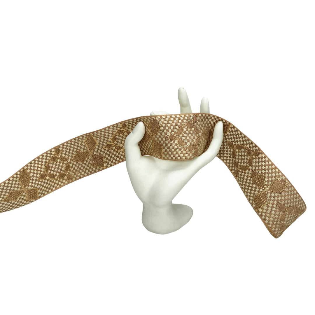 Brown woven headband on a white mannequin head against a white background