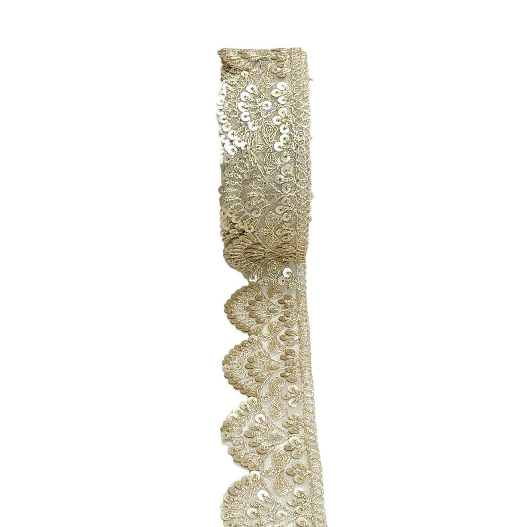 Decorative lace trim with gold embroidery on a white background
