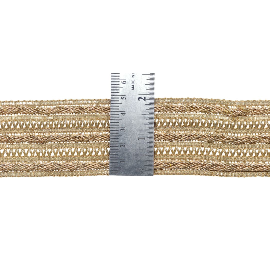 Gold braided cord with a ruler for scale on a white background