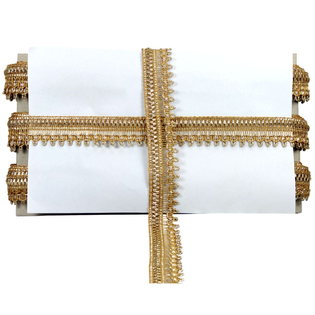Decorative white pillow with gold fringe on a white background