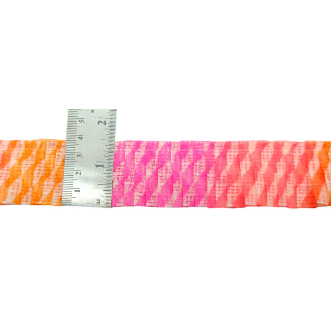 Strip of pink and orange striped fabric with a ruler for scale on a white background