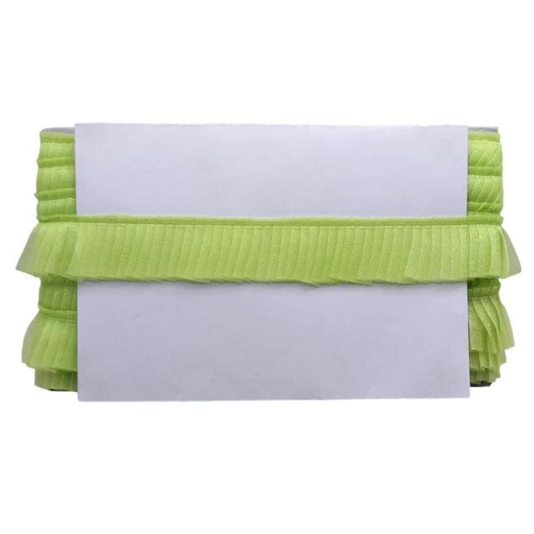 Green ruffled clutch with a white card on a white background