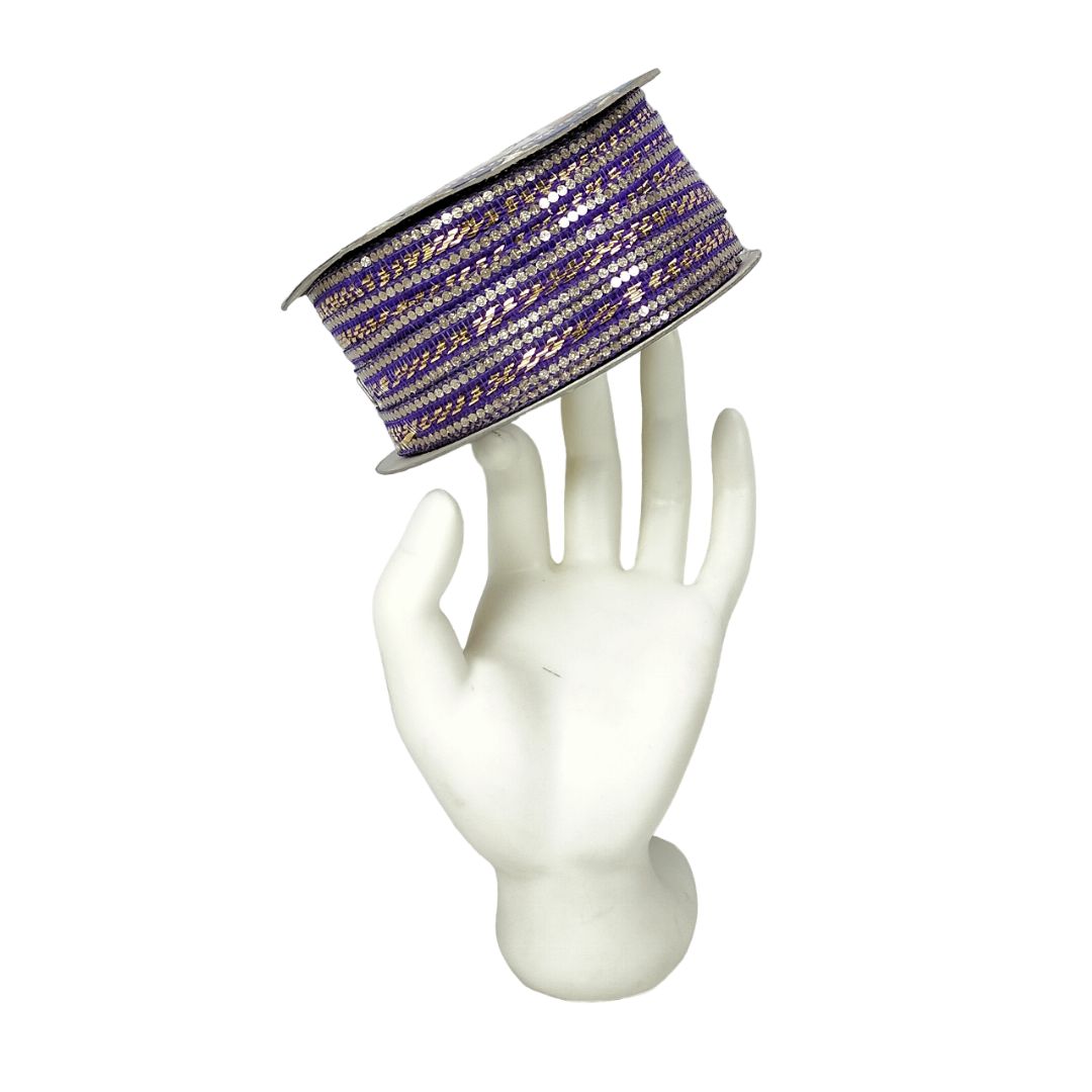 Spool of purple ribbon with gold accents on a white mannequin hand