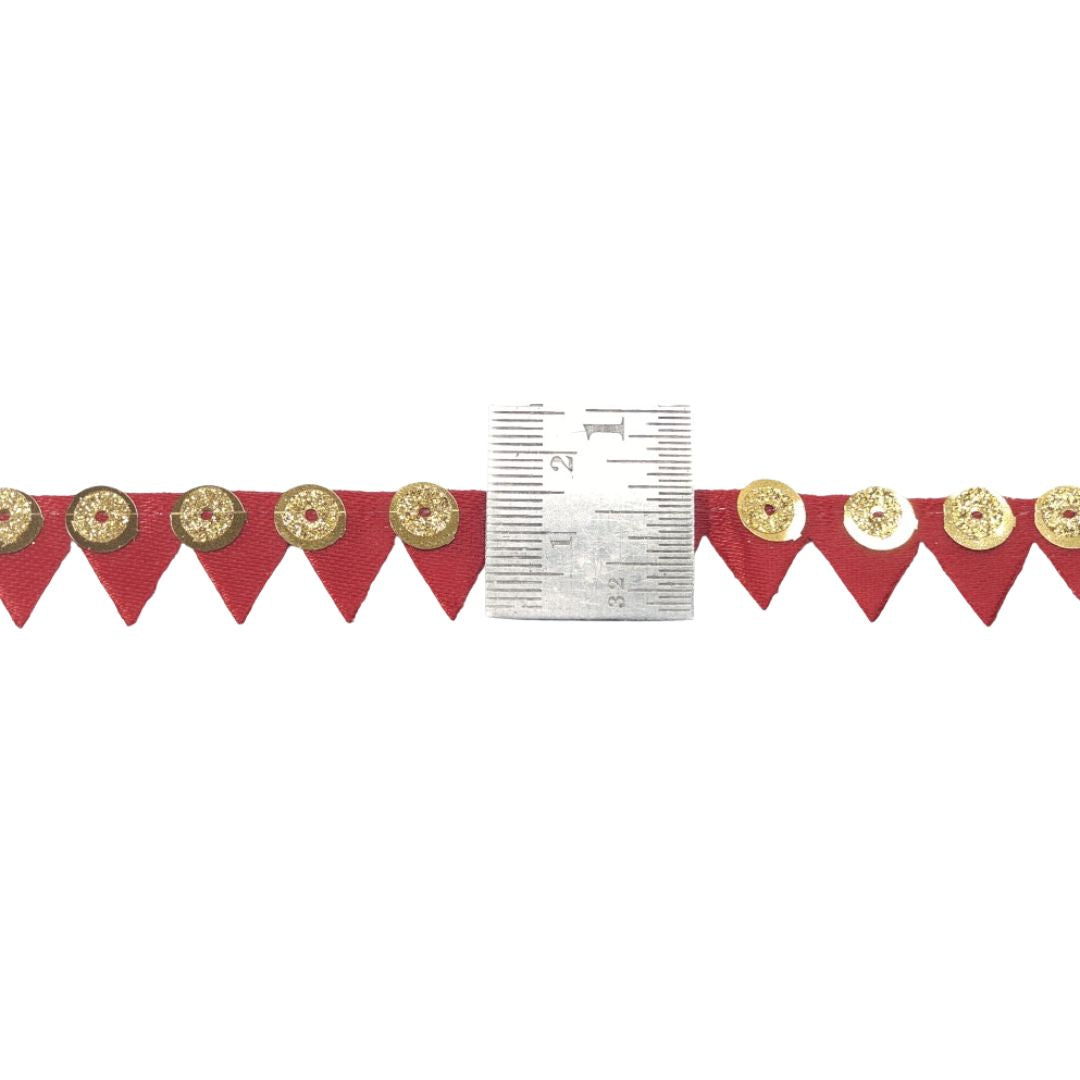 Red banner with gold decorative elements and a ruler for scale on a white background