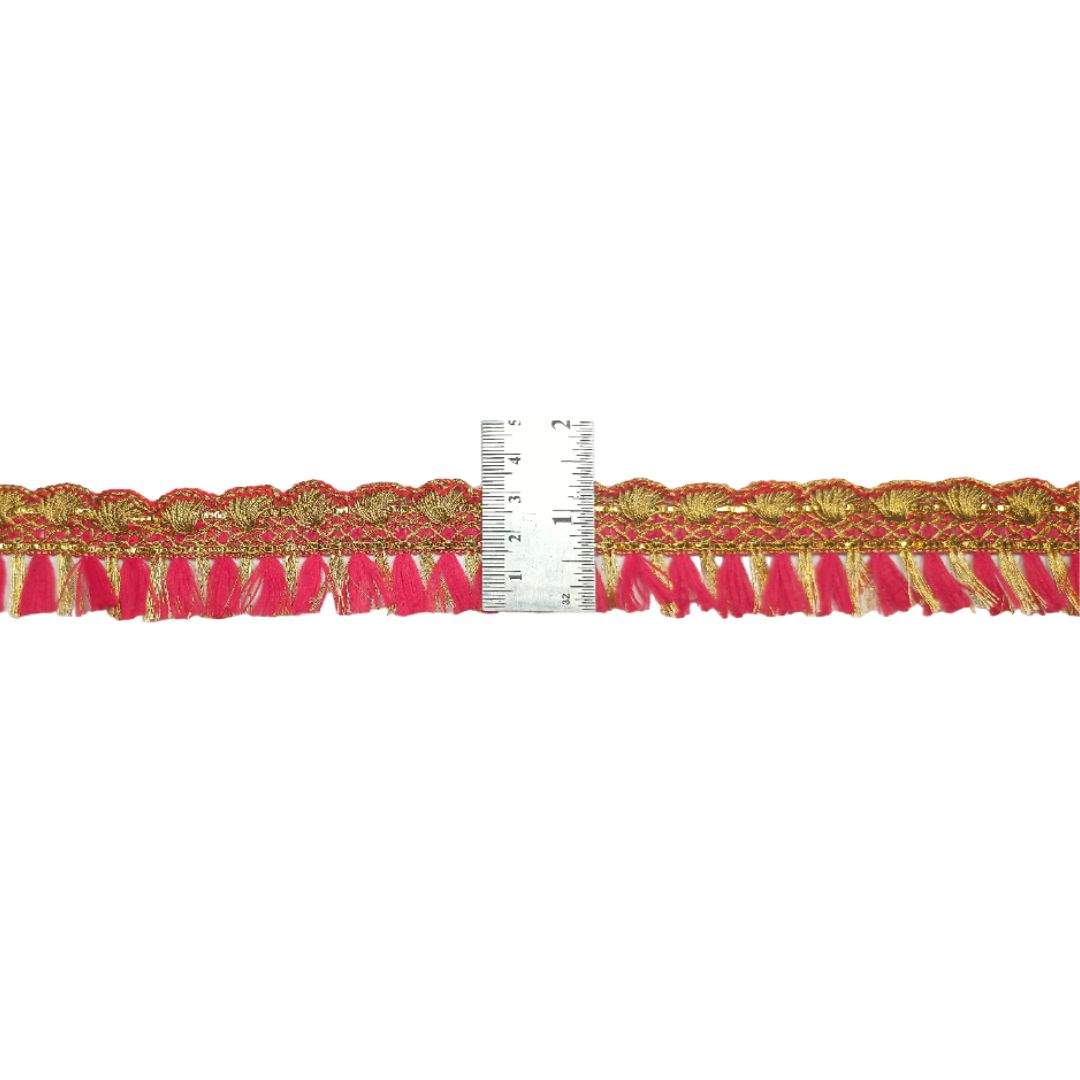 Decorative trim with pink and gold pattern next to a ruler on a white background