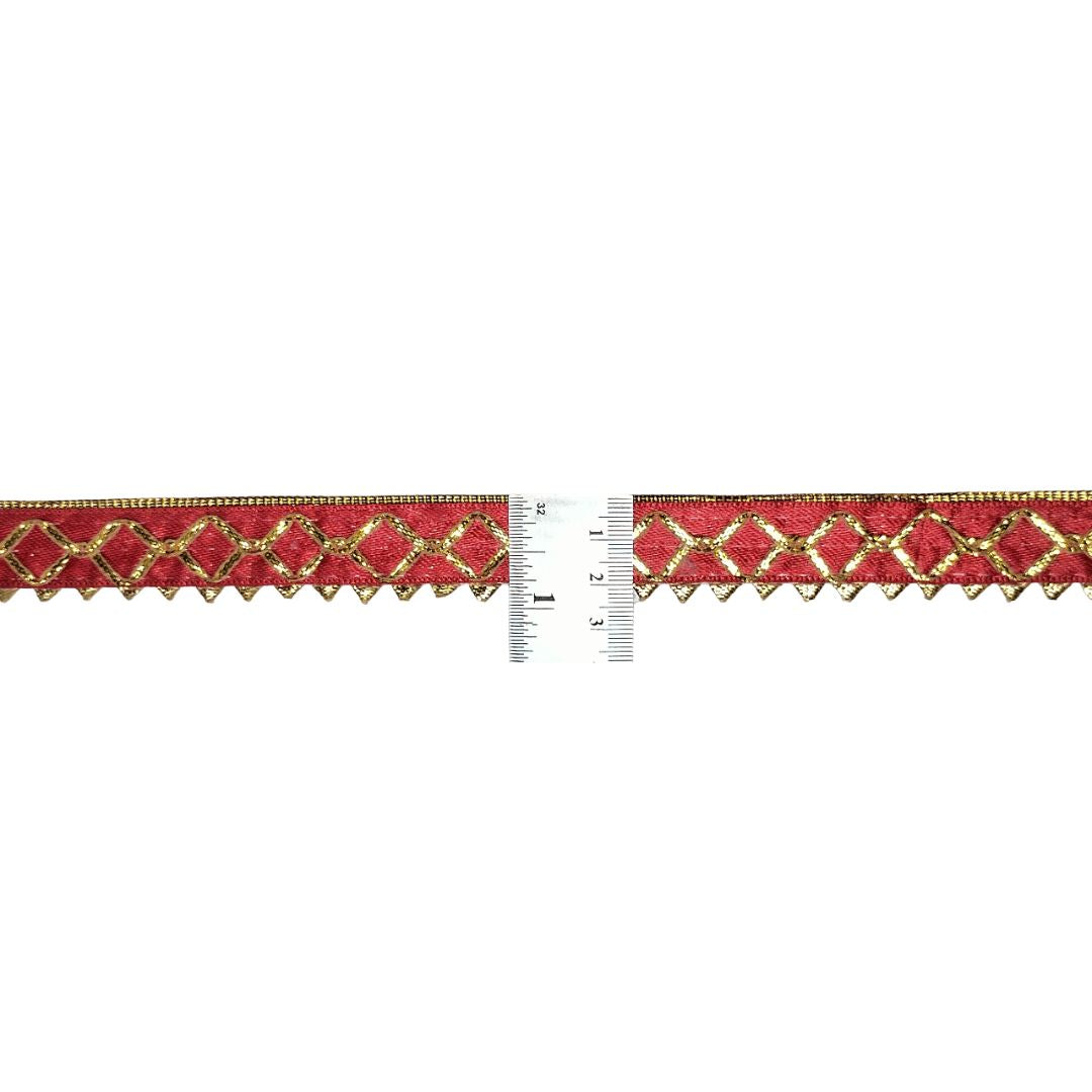 Red and gold decorative ribbon with a ruler for scale on a white background