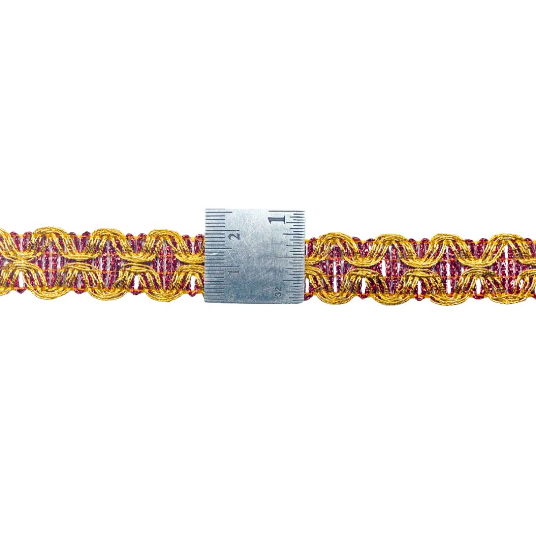 Gold and pink braided trim with a ruler for scale on a white background