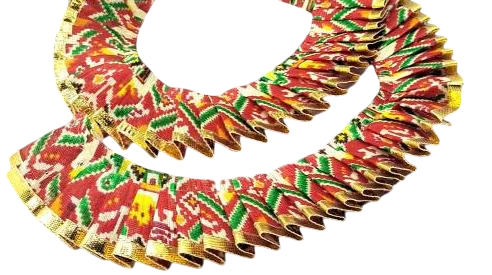 Colorful African print fabric with red, green, and gold patterns on a white background