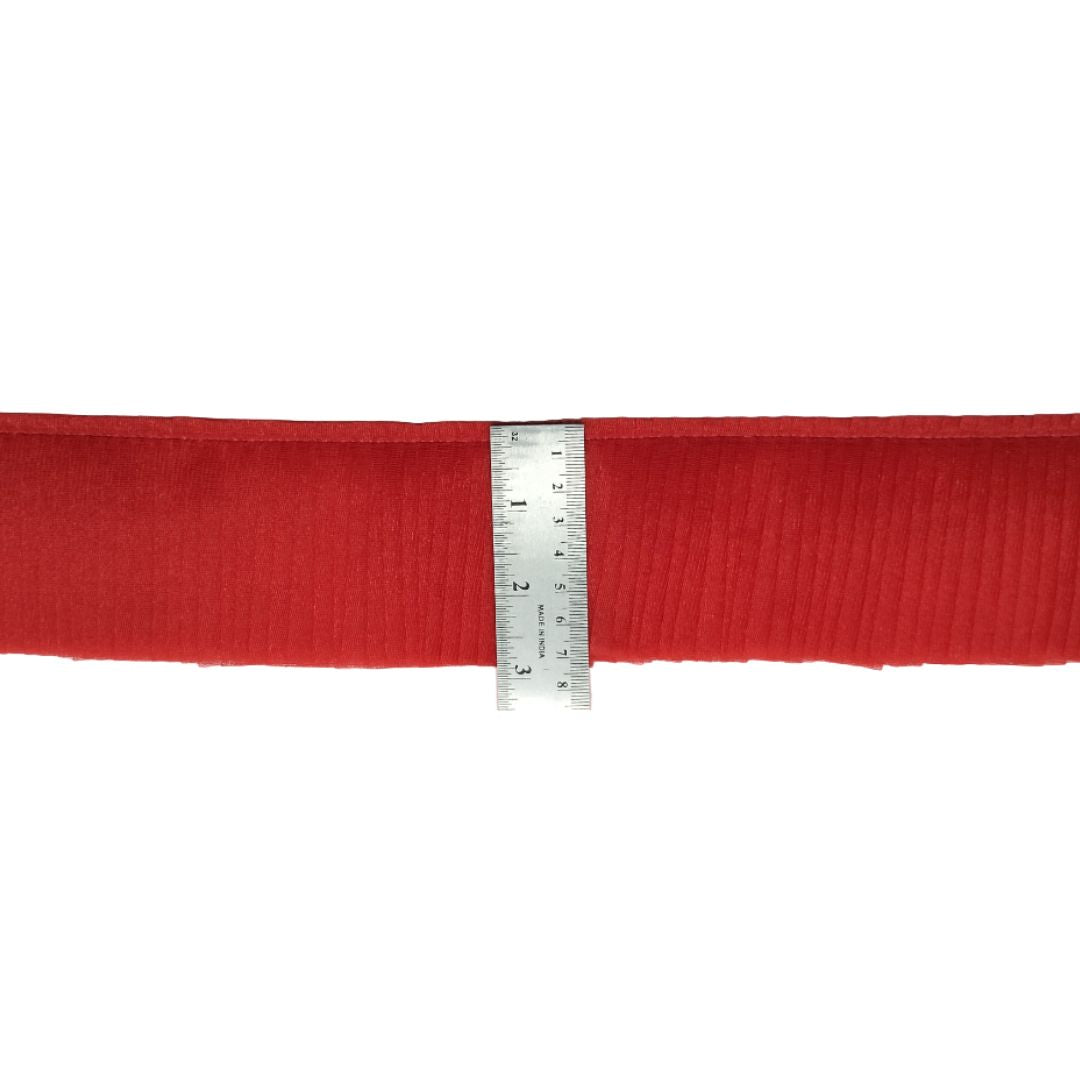 Red fabric with a ruler for scale on a white background
