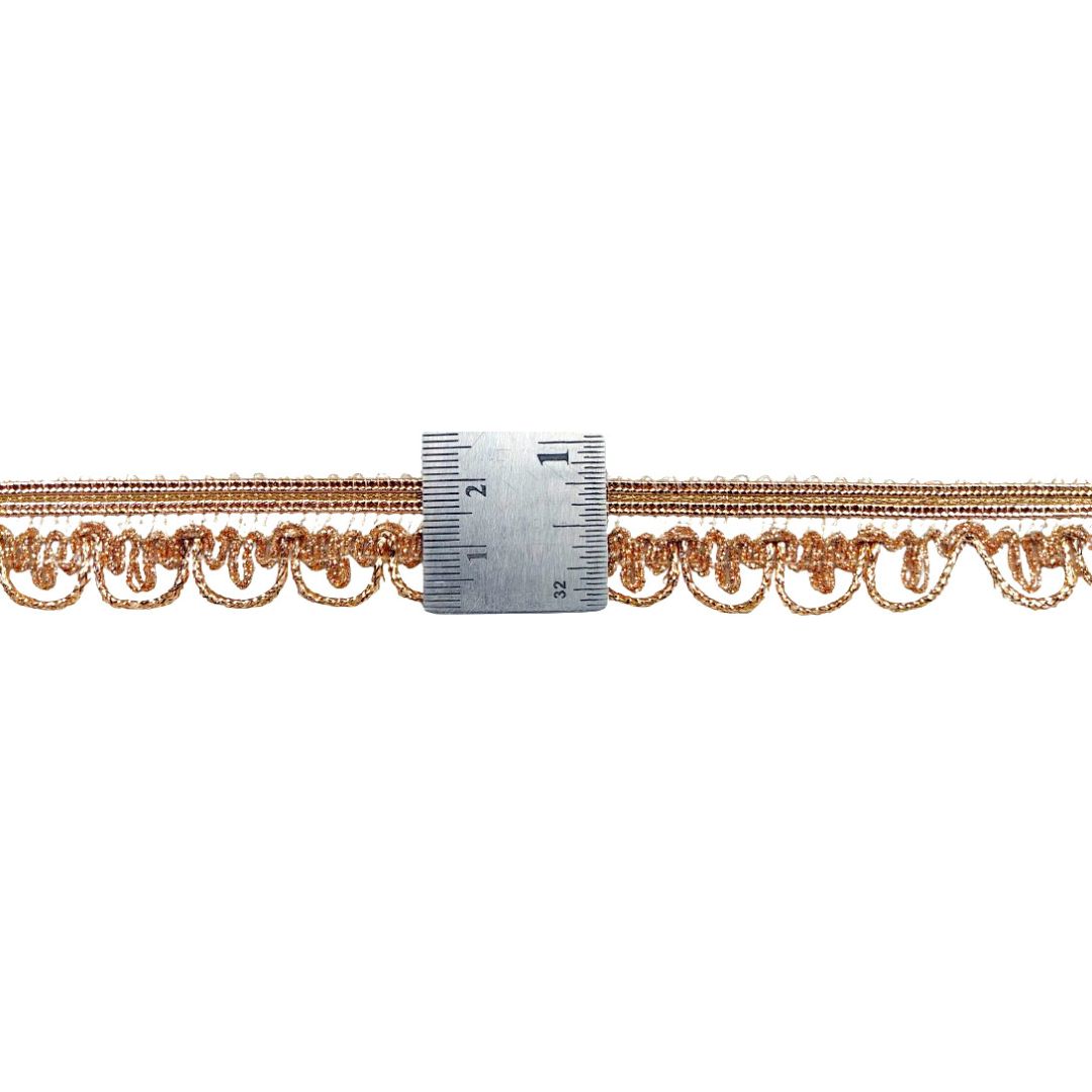 Decorative gold chain with a ruler for scale on a white background