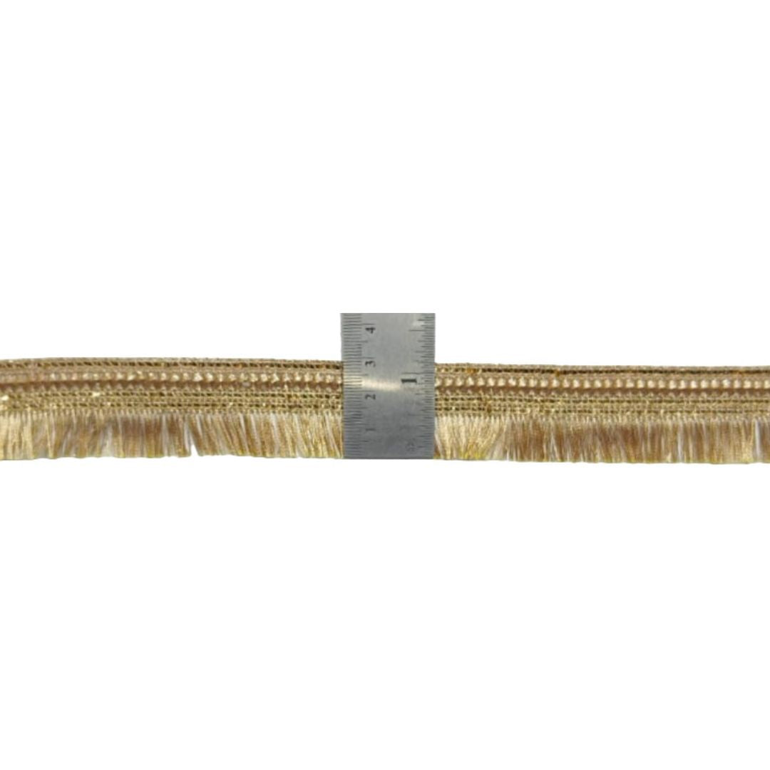Gold fringe trim with a ruler for scale on a white background