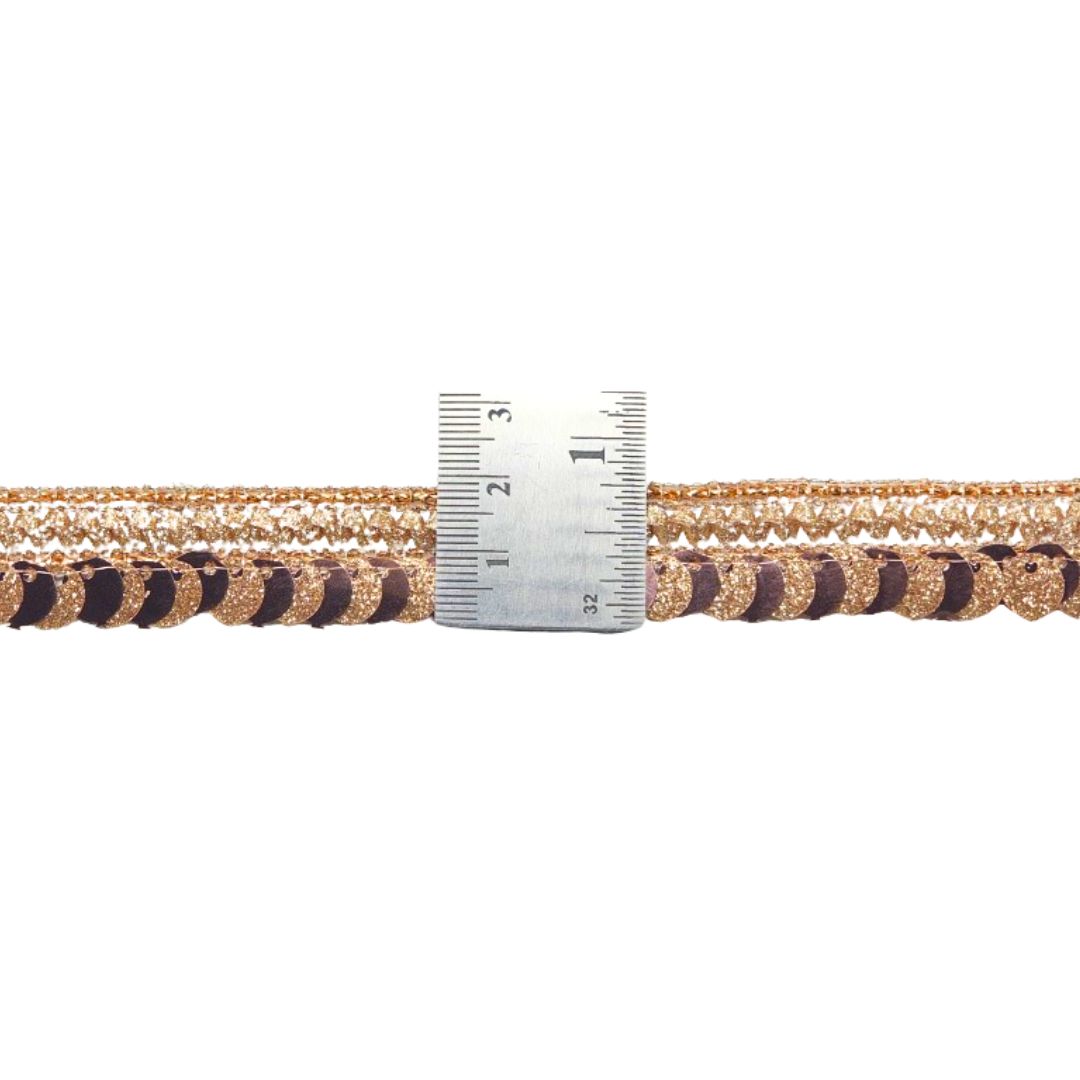 Gold and brown braided cord with a ruler for scale on a white background