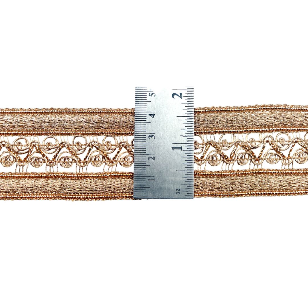 Decorative lace trim with a ruler for scale on a white background