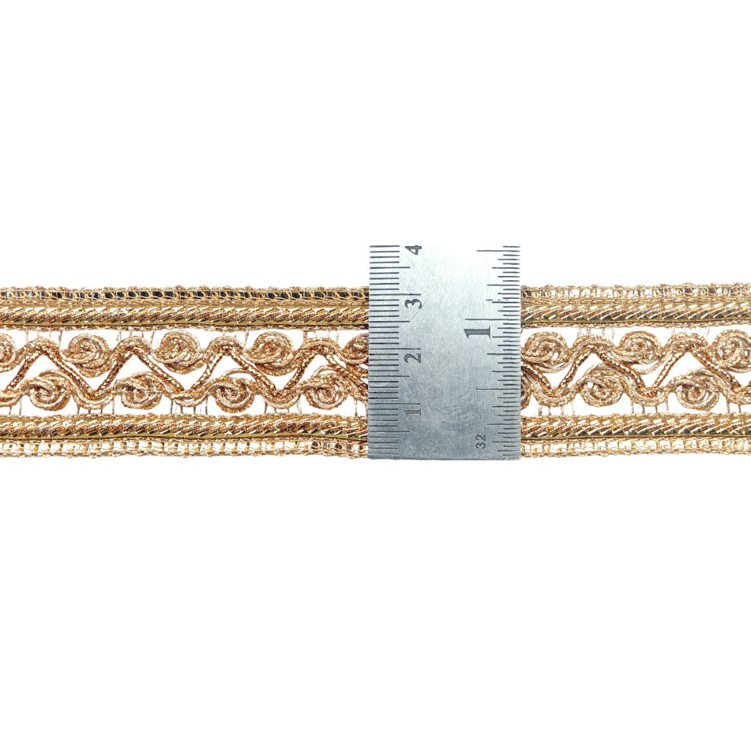 Gold lace trim with a ruler for measurement on a white background