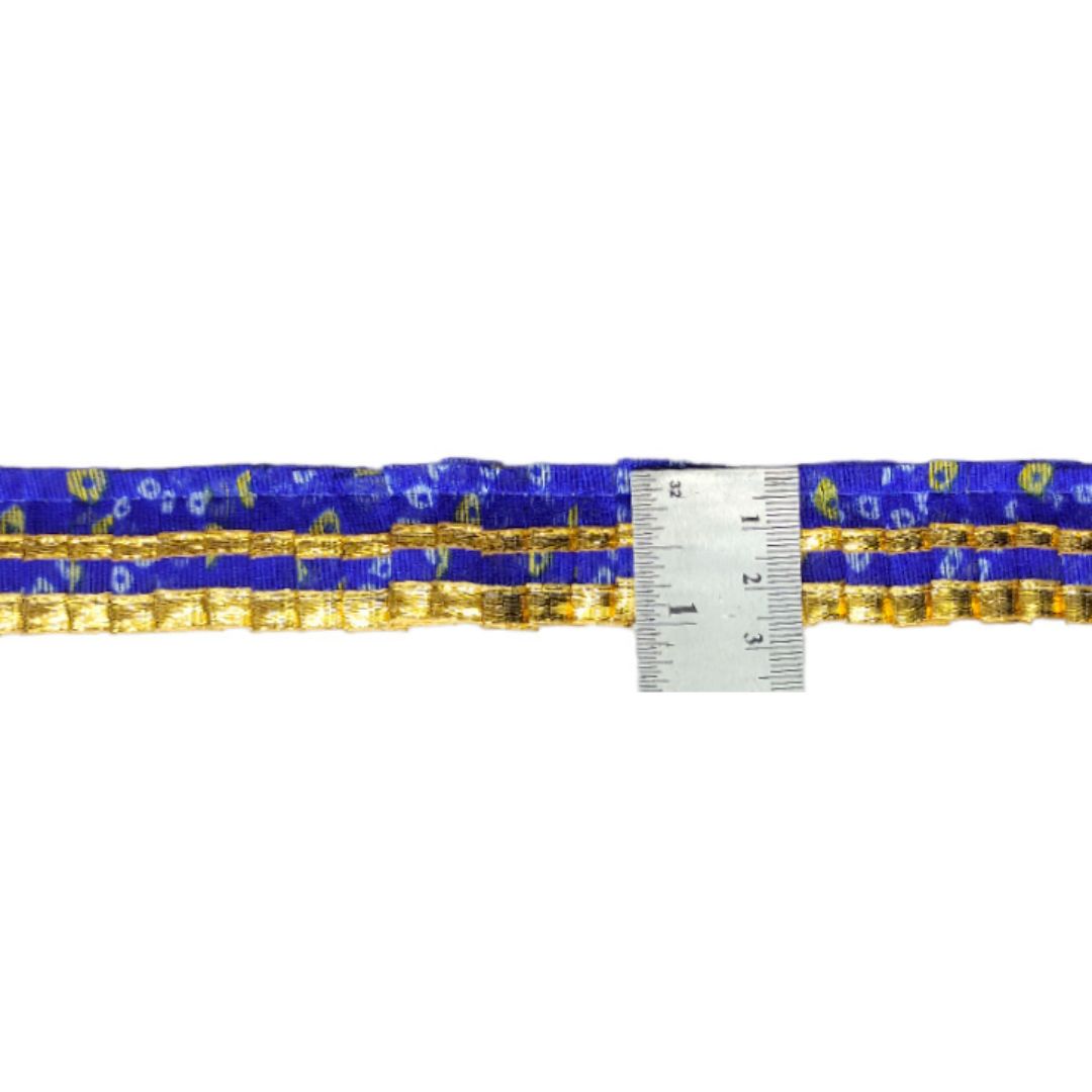 Blue and gold patterned belt with a measuring tape for scale on a white background