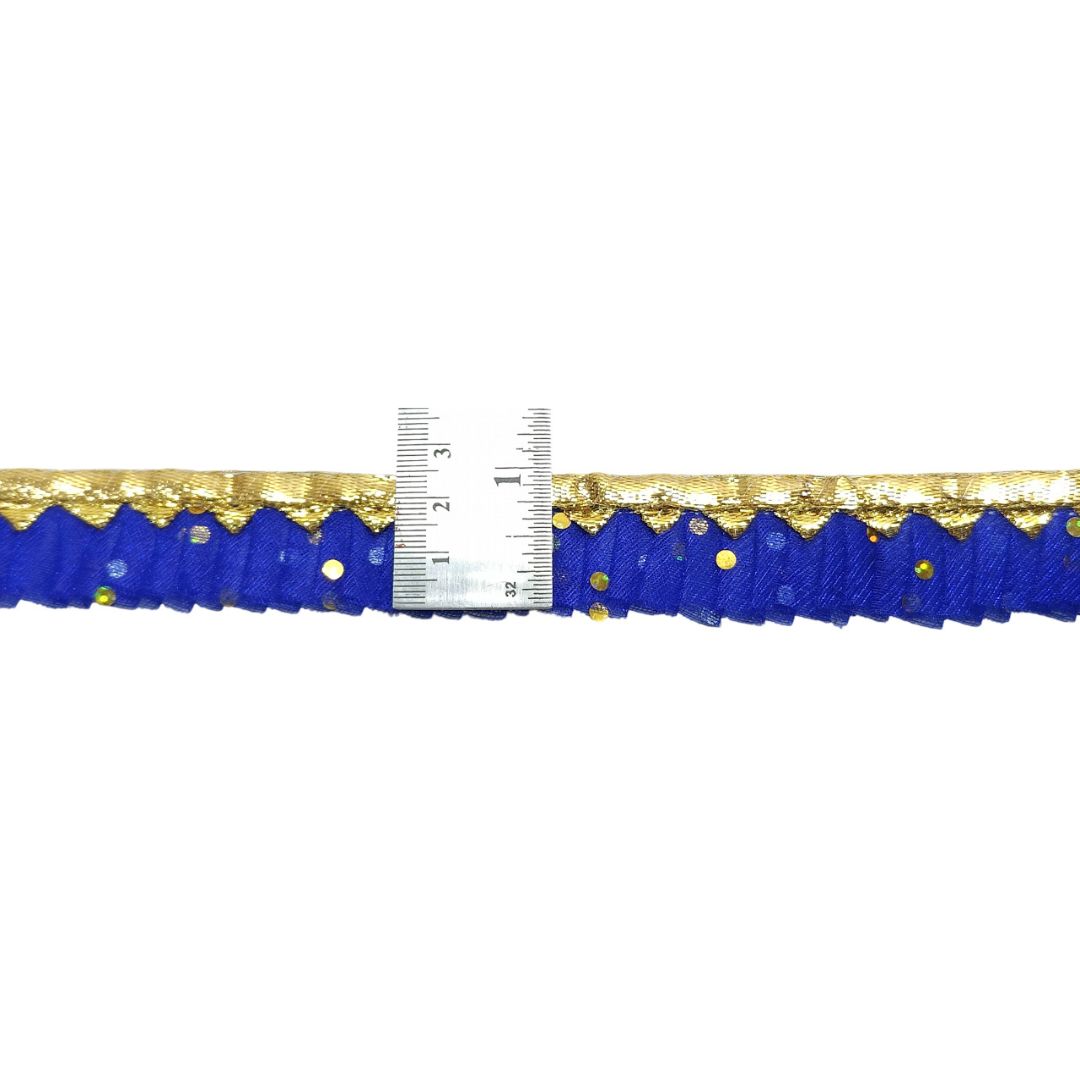 Blue ribbon with gold edge and a ruler for scale on a white background