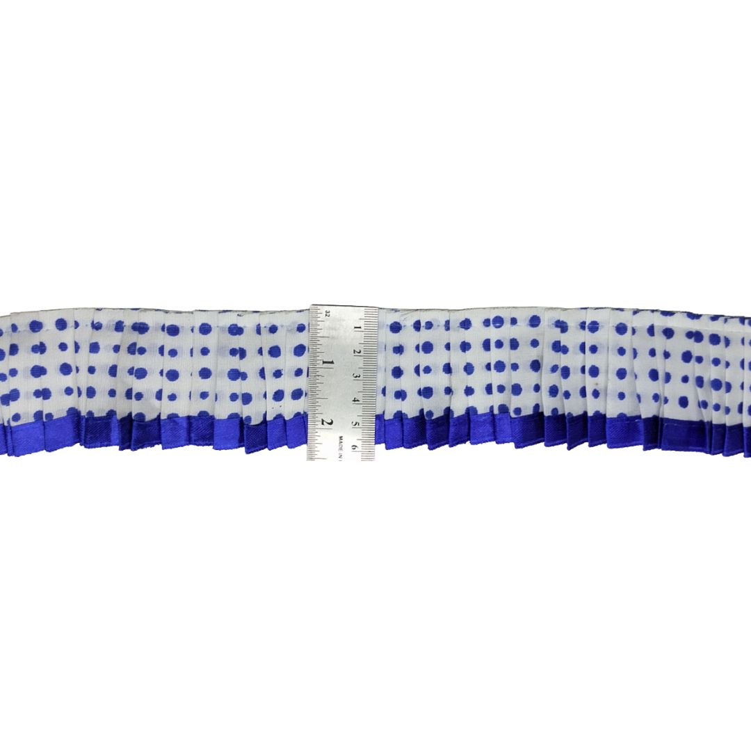 Blue polka dot ribbon with a ruler for scale on a white background