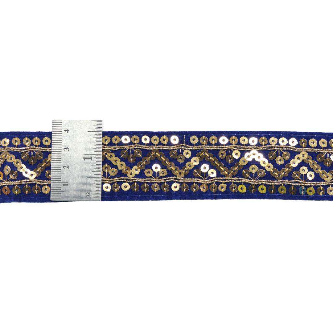 Decorative ribbon with gold and white pattern on a blue background, measured against a ruler.
