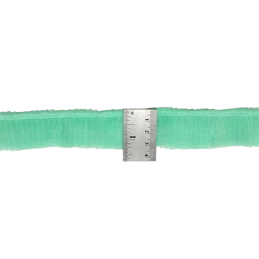 Green ribbon with a metal ruler for measurement on a white background