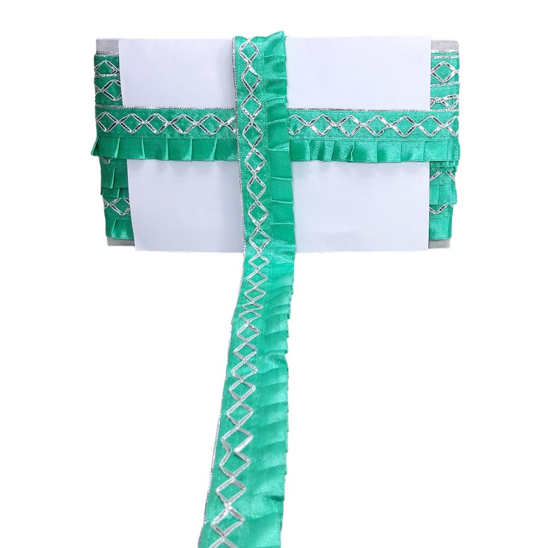 Green and white decorative item with ruffled edges on a white background
