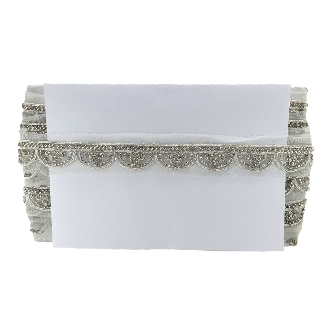 White clutch with silver beaded embellishments on a white background