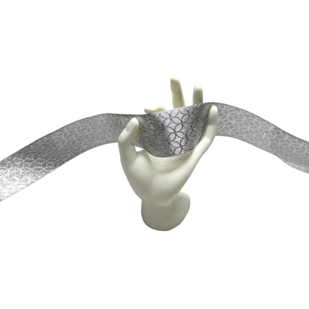 Mannequin hand holding a silver metallic fabric on a white background