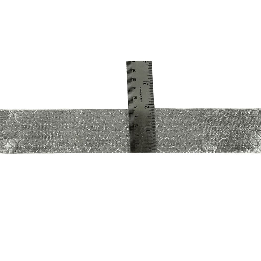 Silver metallic ribbon with a ruler for measurement on a white background