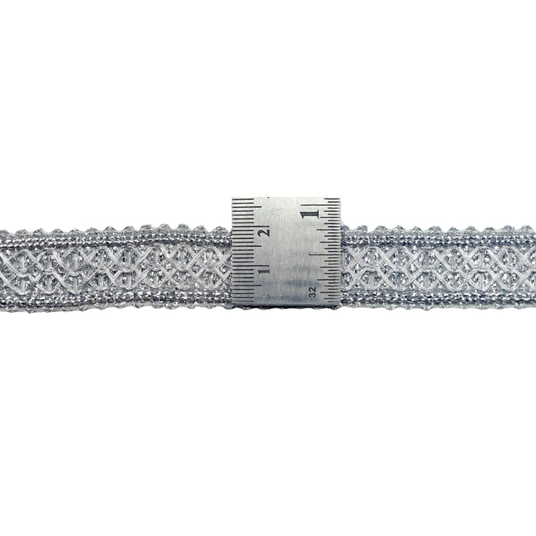 Decorative lace trim with a ruler for scale on a white background