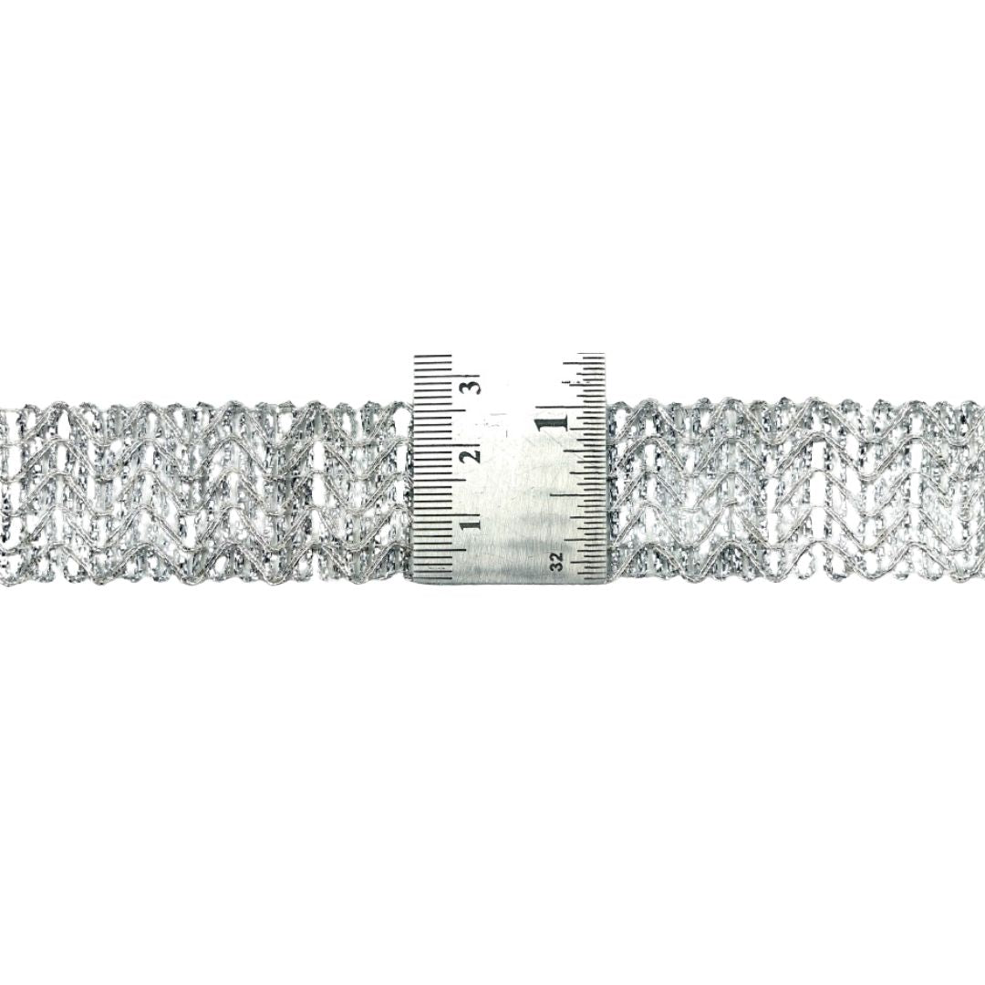 Silver bracelet with a ruler for size reference on a white background