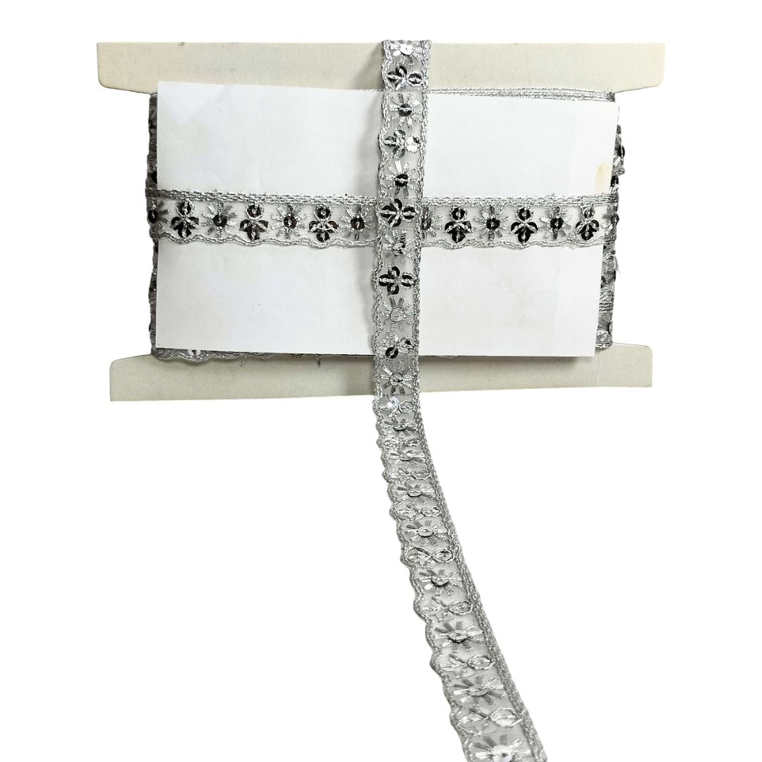 Silver decorative ribbon with intricate patterns on a white background