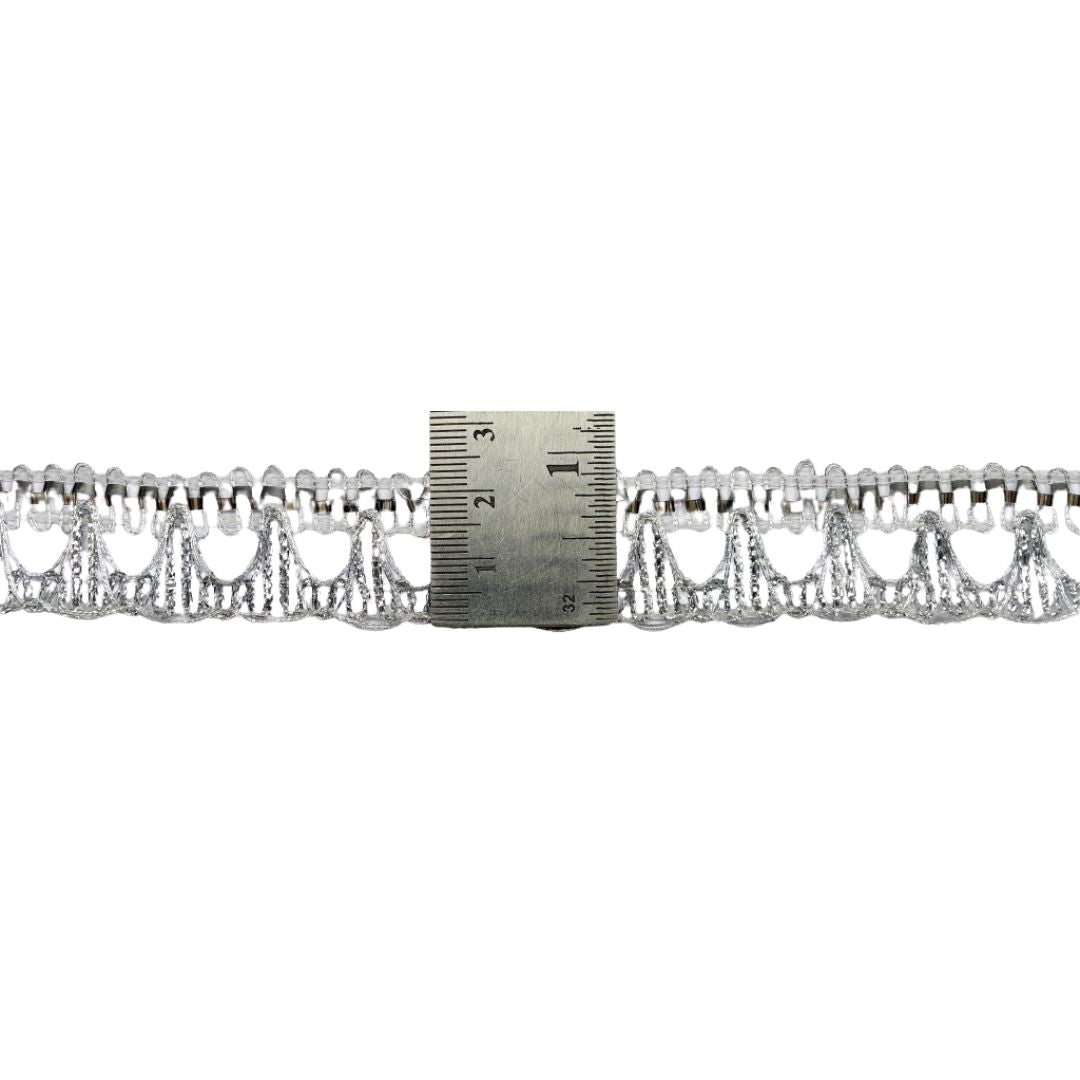 Decorative lace trim with a ruler for scale on a white background