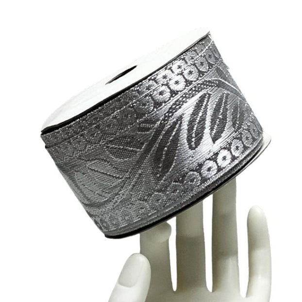 Silver bracelet with leaf design on a white mannequin hand against a white background
