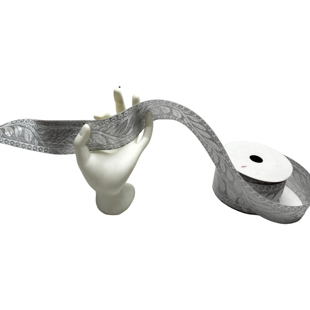 Gray patterned ribbon with a white mannequin head and a roll of ribbon on a white background