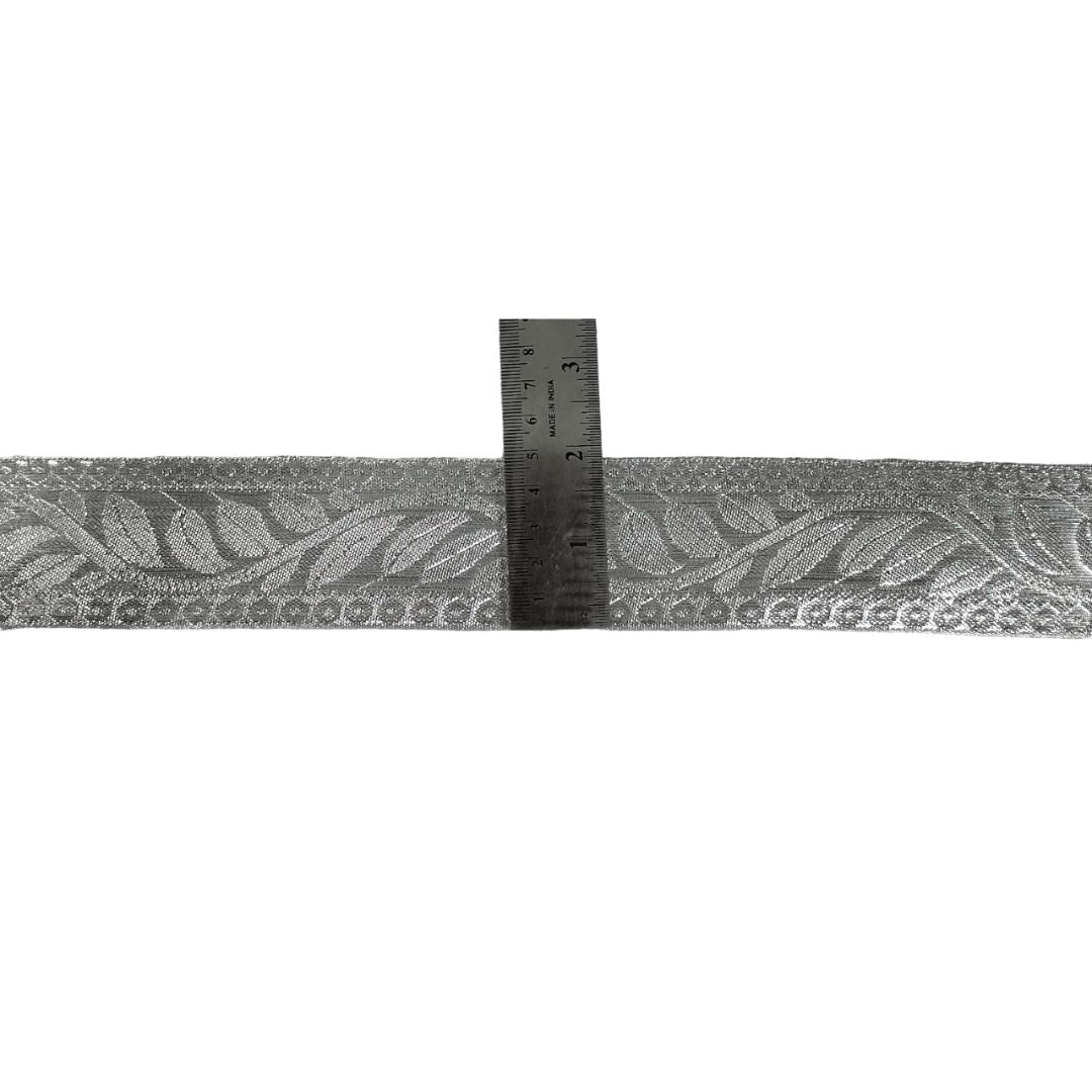 Gray lace ribbon with a ruler for scale on a white background