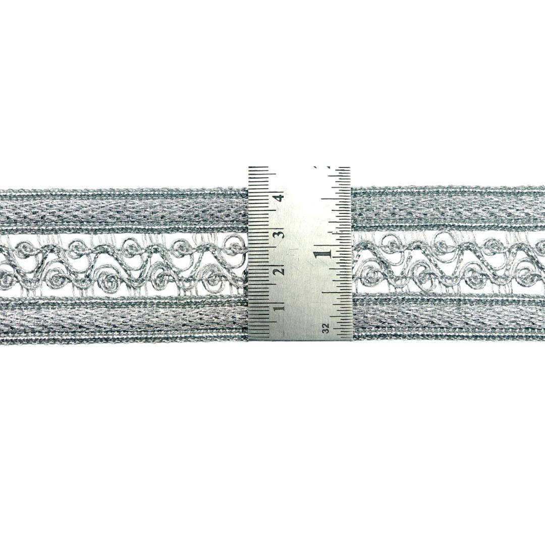 Decorative metallic trim with a ruler for scale on a white background