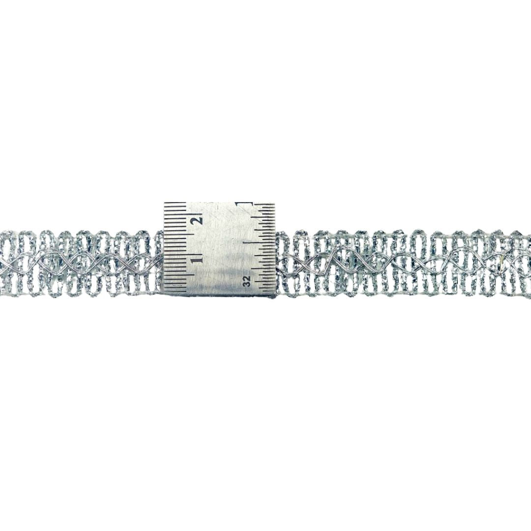 Silver lace trim with a ruler for measurement on a white background