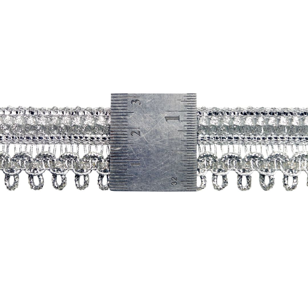 Close-up of decorative trim with a ruler for scale on a white background