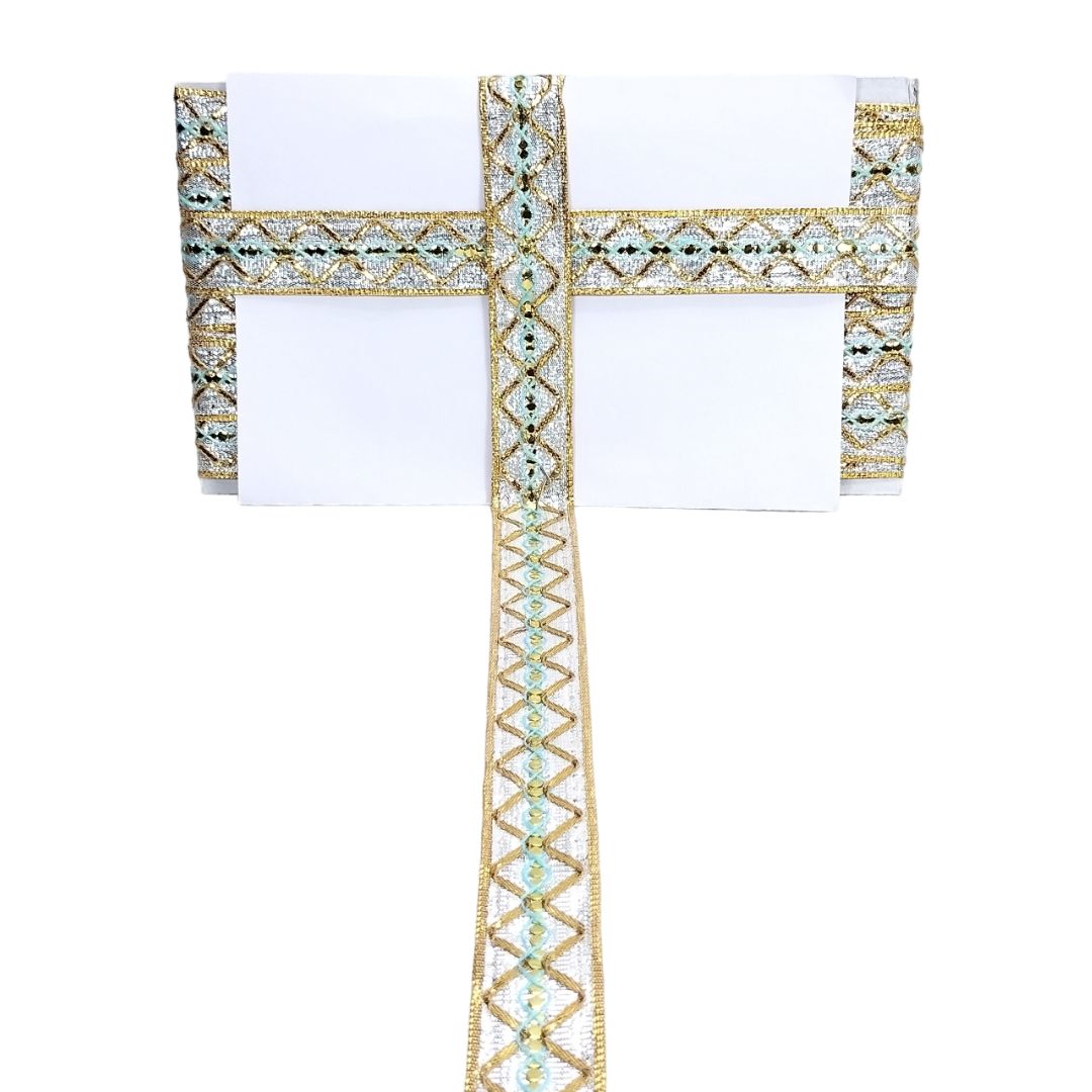 Decorative headband with gold and green gemstones on a white background