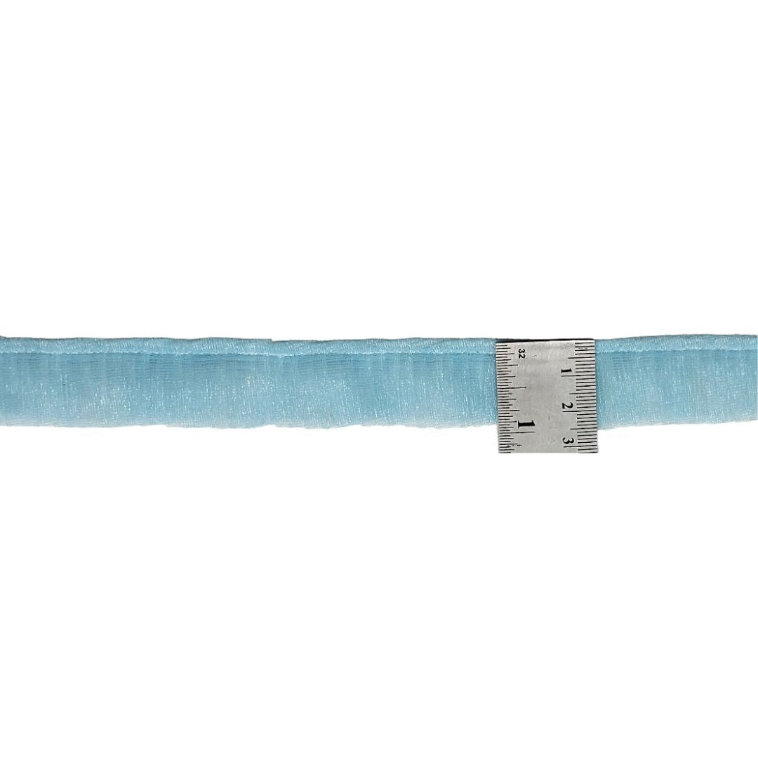 Light blue fabric with a metal ruler on a white background