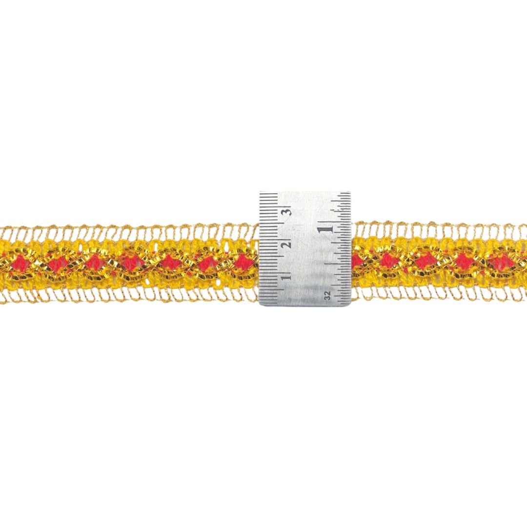 Gold lace trim with red floral patterns and a ruler for scale on a white background