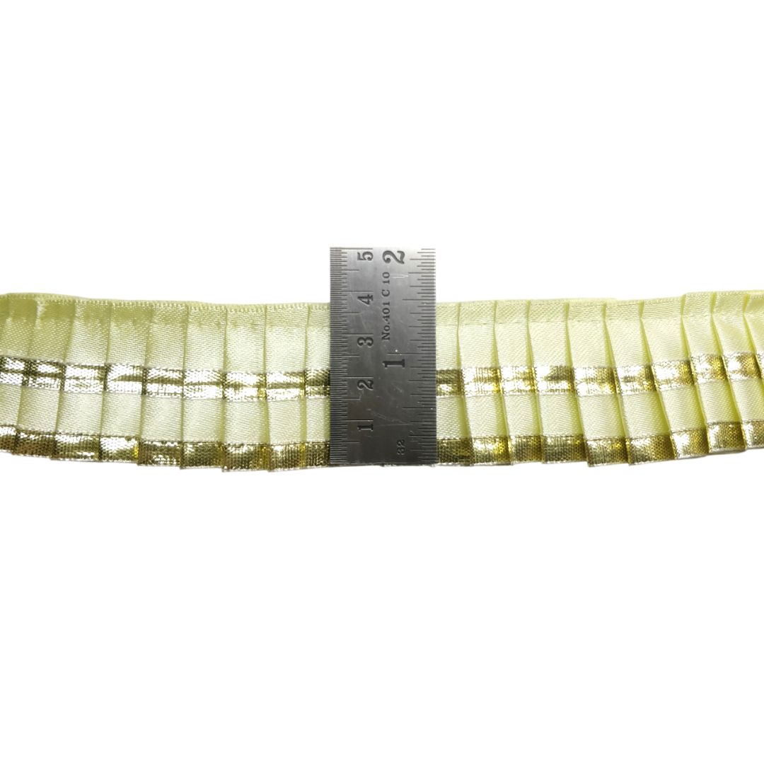 Green pleated ribbon with a ruler for measurement on a white background