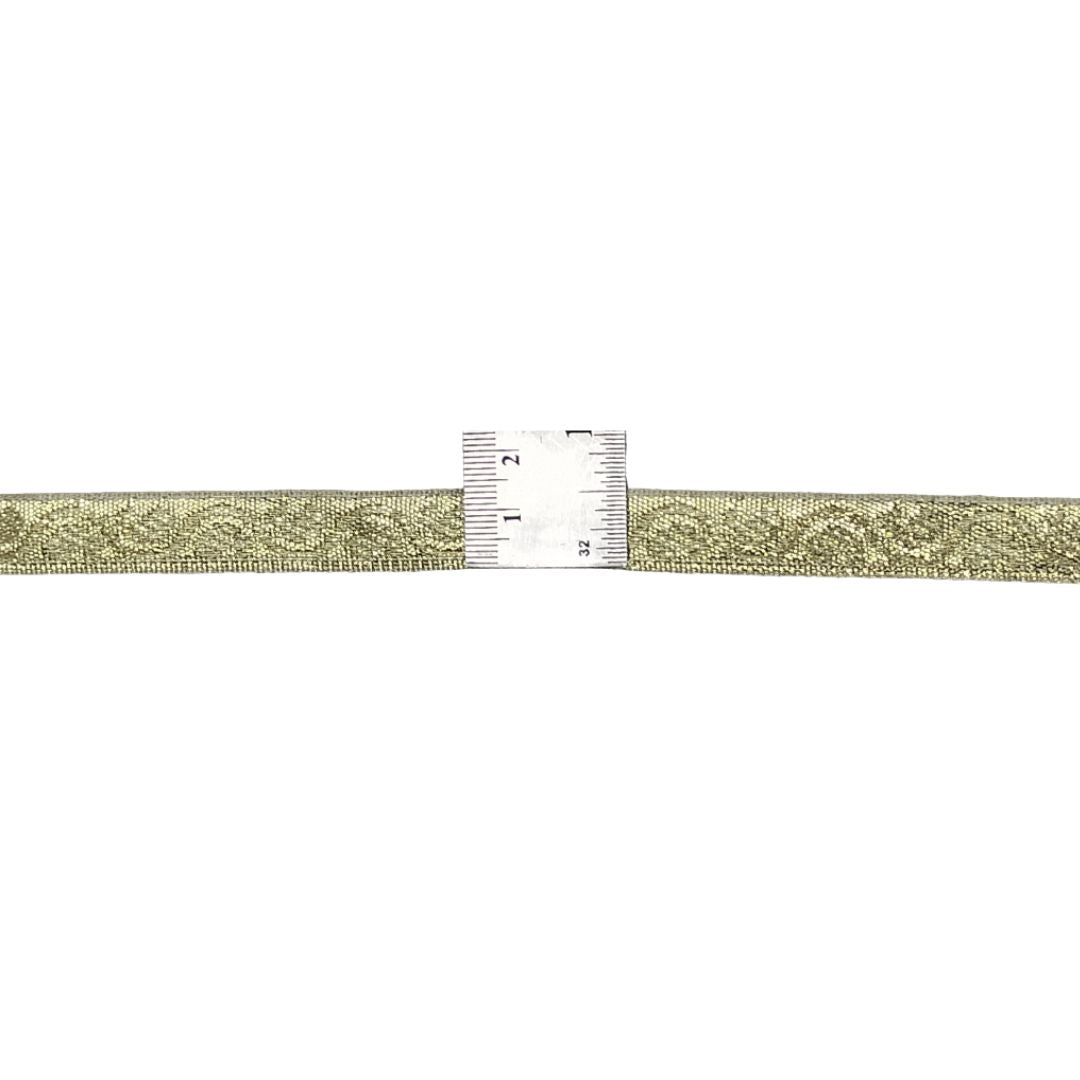 Gold woven belt with a ruler for scale on a white background