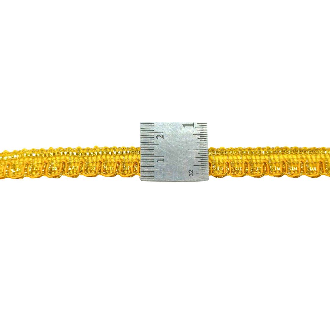 Gold chain with a ruler for scale on a white background