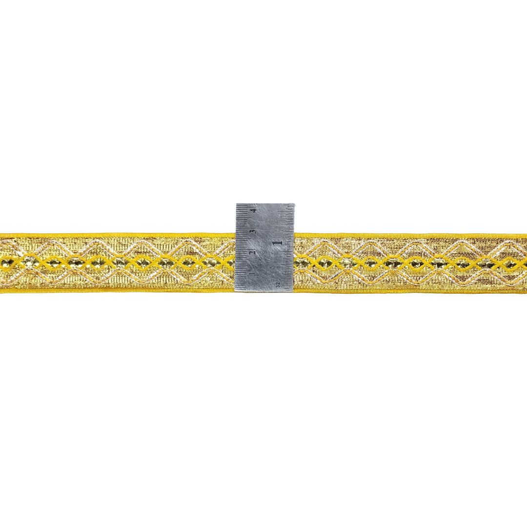 Decorative yellow ribbon with a metal ruler for scale on a white background