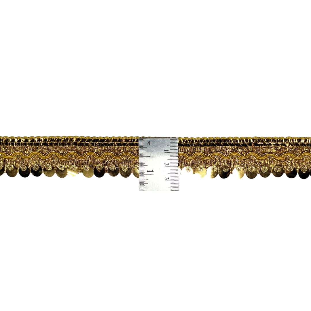 Gold lace trim with a ruler for scale on a white background